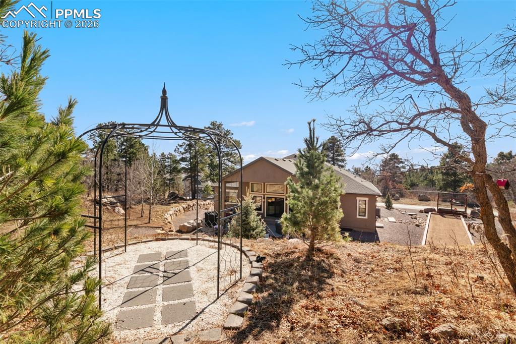 Winding pathways lead to a secluded garden gazebo, offering a tranquil destination on the property for morning coffee or quiet reflection surrounded by nature
