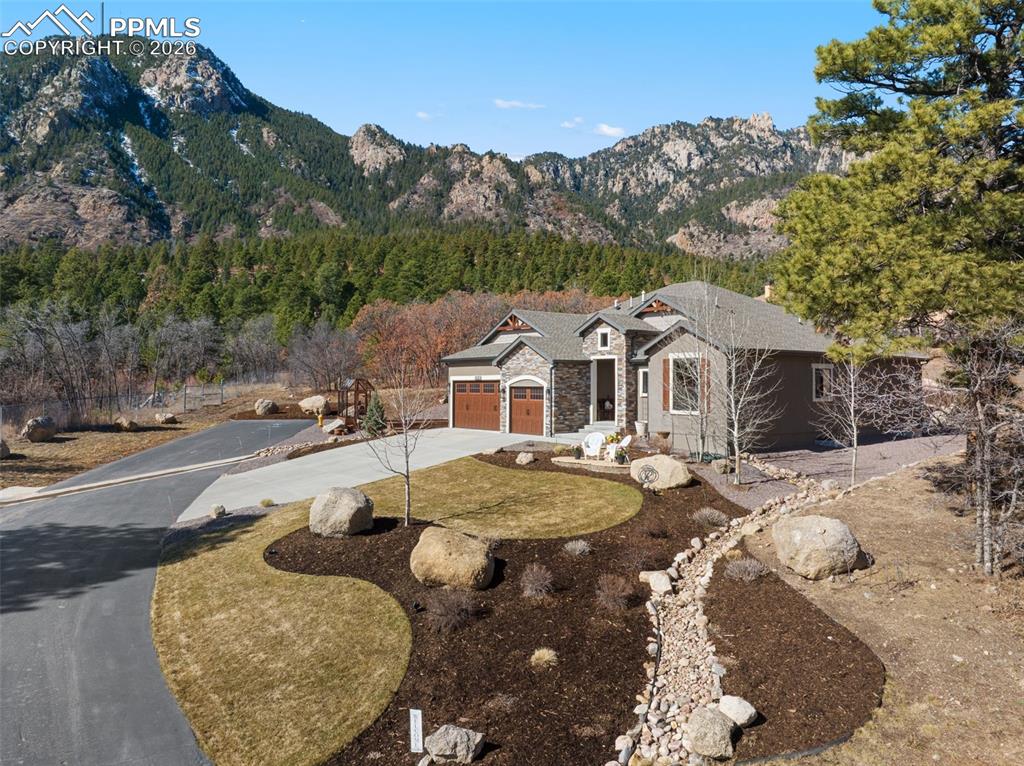 Curated landscaping softens the approach to the residence, utilizing native boulders and sweeping beds with peaks rising immediately behind the property
