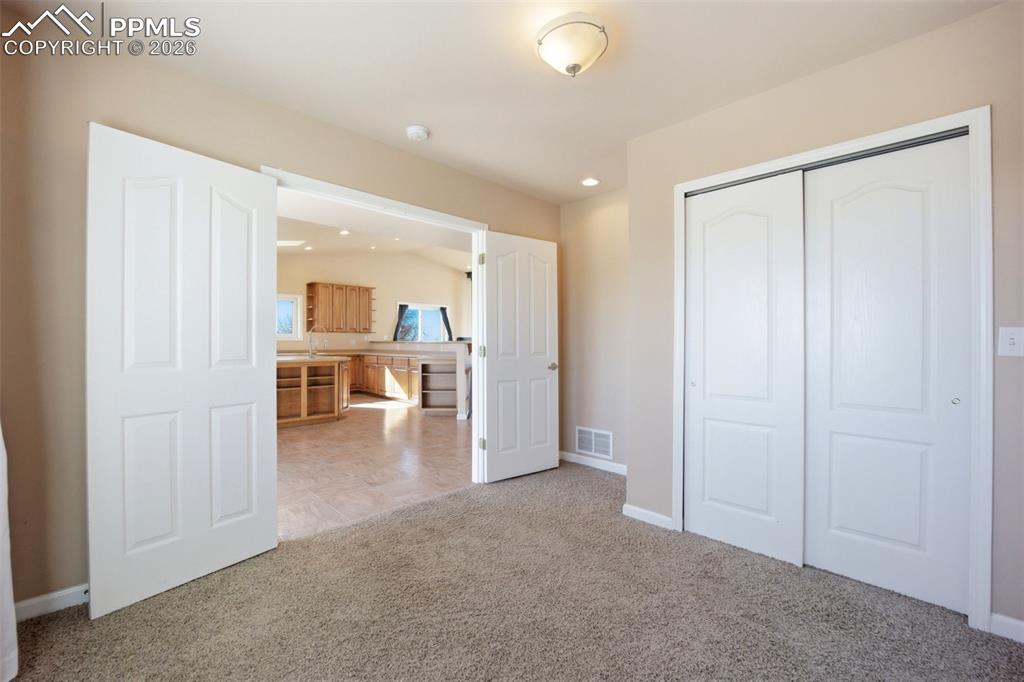Main level bedroom or office, with a closet and carpet
