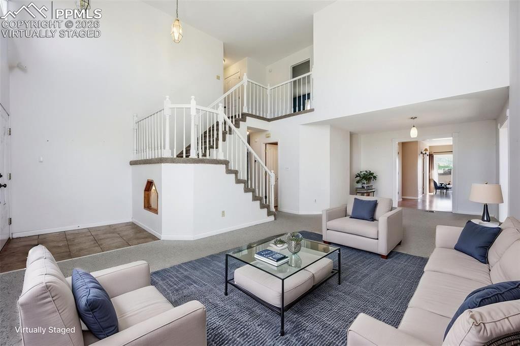 Virtually staged living room with a high vaulted ceiling