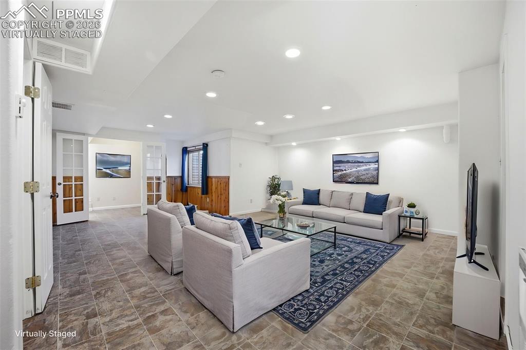 Virtually staged large basement area with small office area with french doors