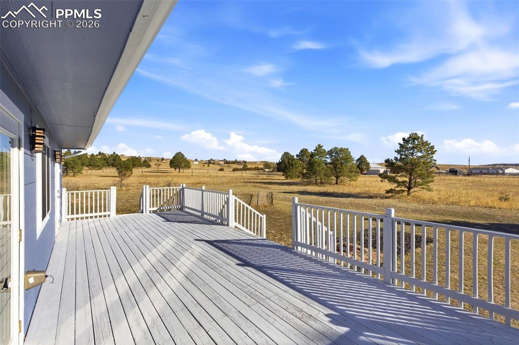 Large wooden deck with a view of rural / pastoral area
