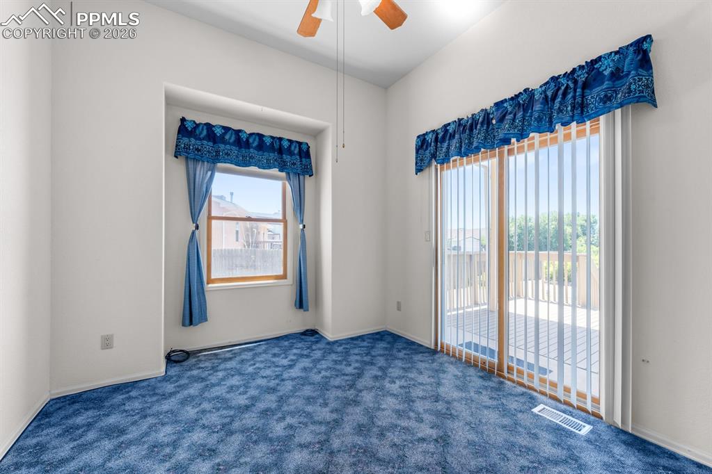 Carpeted empty room with a ceiling fan and baseboards