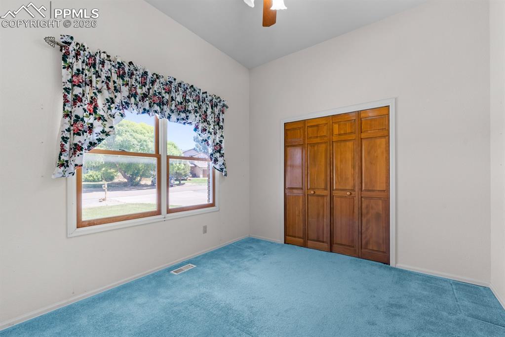 Unfurnished bedroom featuring carpet, ceiling fan, and a closet