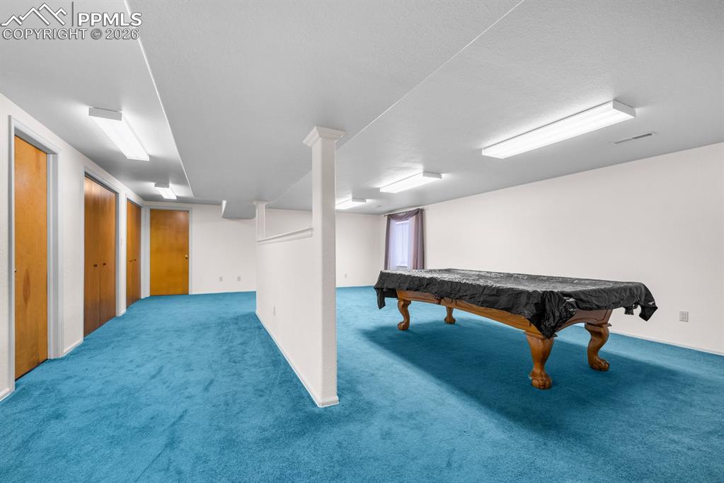 Recreation room with carpet floors and billiards