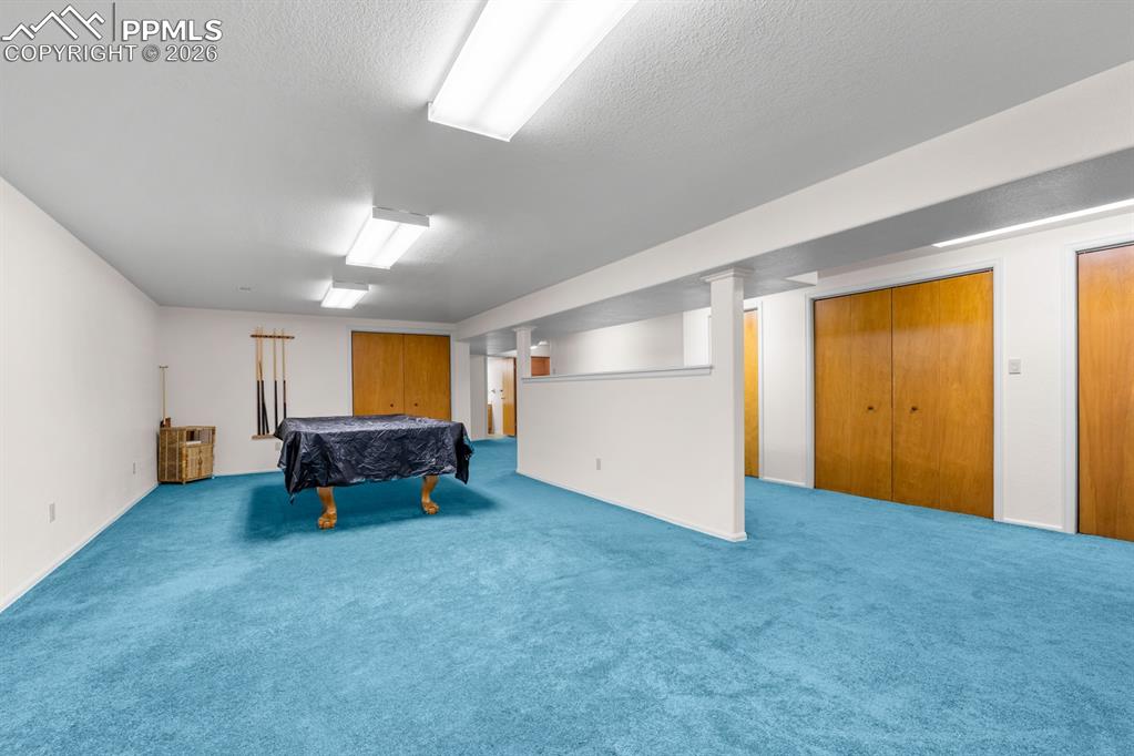 Playroom featuring billiards, carpet flooring, and a textured ceiling