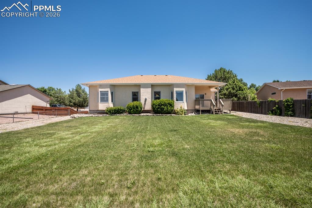 Back of house featuring a wooden deck and stucco siding