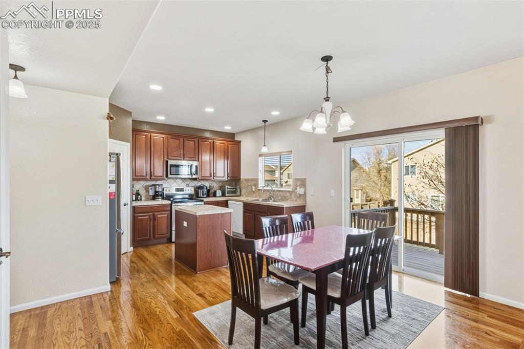 Dining space with a chandelier, light wood-type flooring, and recessed lighting