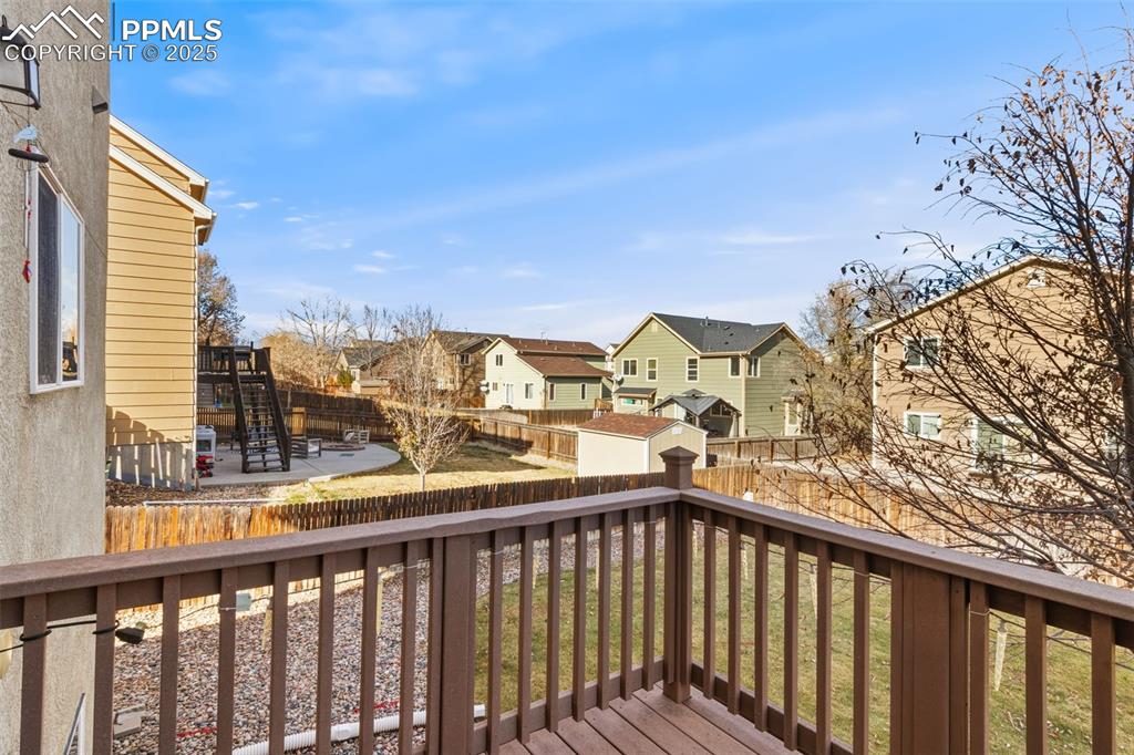 Deck with a residential view, a fenced backyard, a shed, and stairway