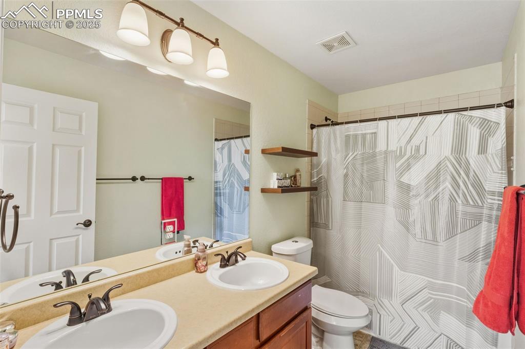 Full bath with double vanity and curtained shower