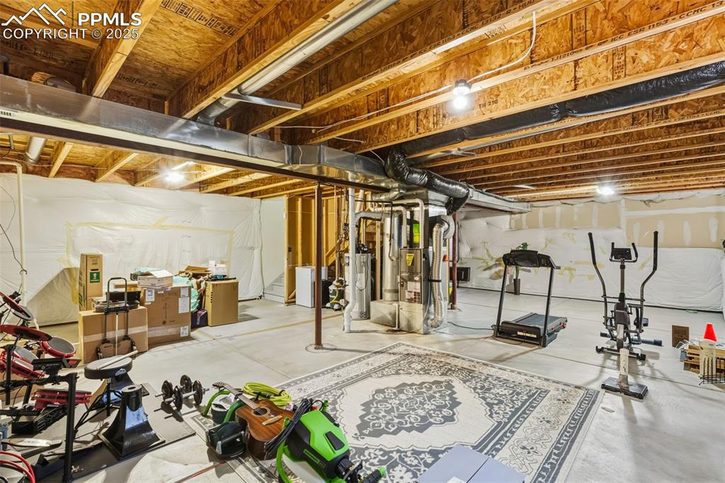 Unfinished below grade area with water heater and washer / dryer