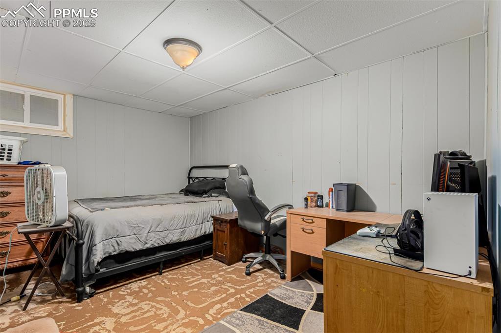 Bedroom with a drop ceiling and an office area