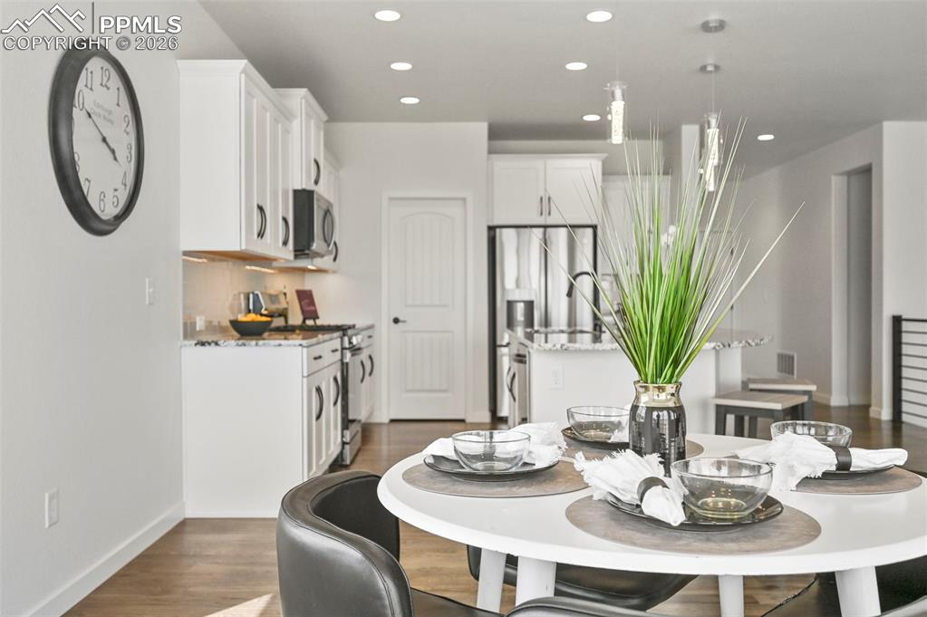 Dining area with recessed lighting and dark wood-style flooring