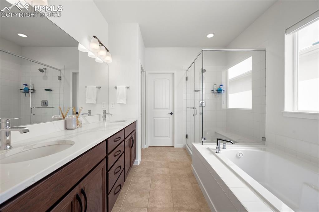 Full bathroom featuring a stall shower, double vanity, a garden tub, recessed lighting, and tile patterned floors