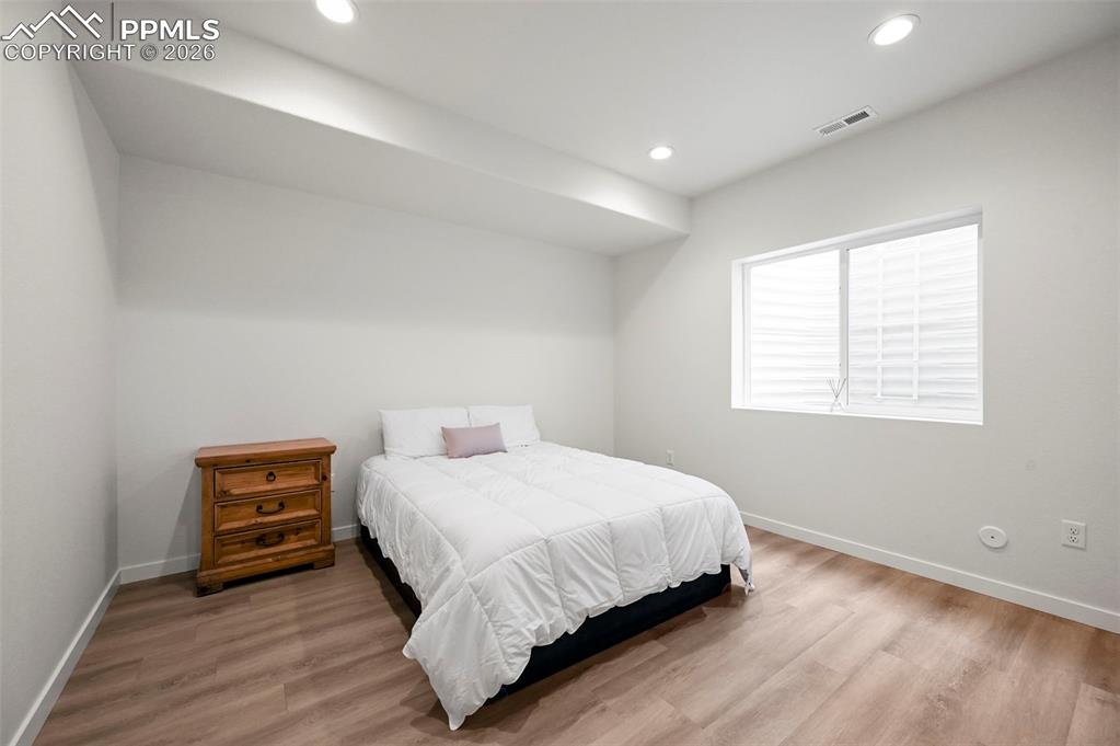 Bedroom with wood finished floors and recessed lighting