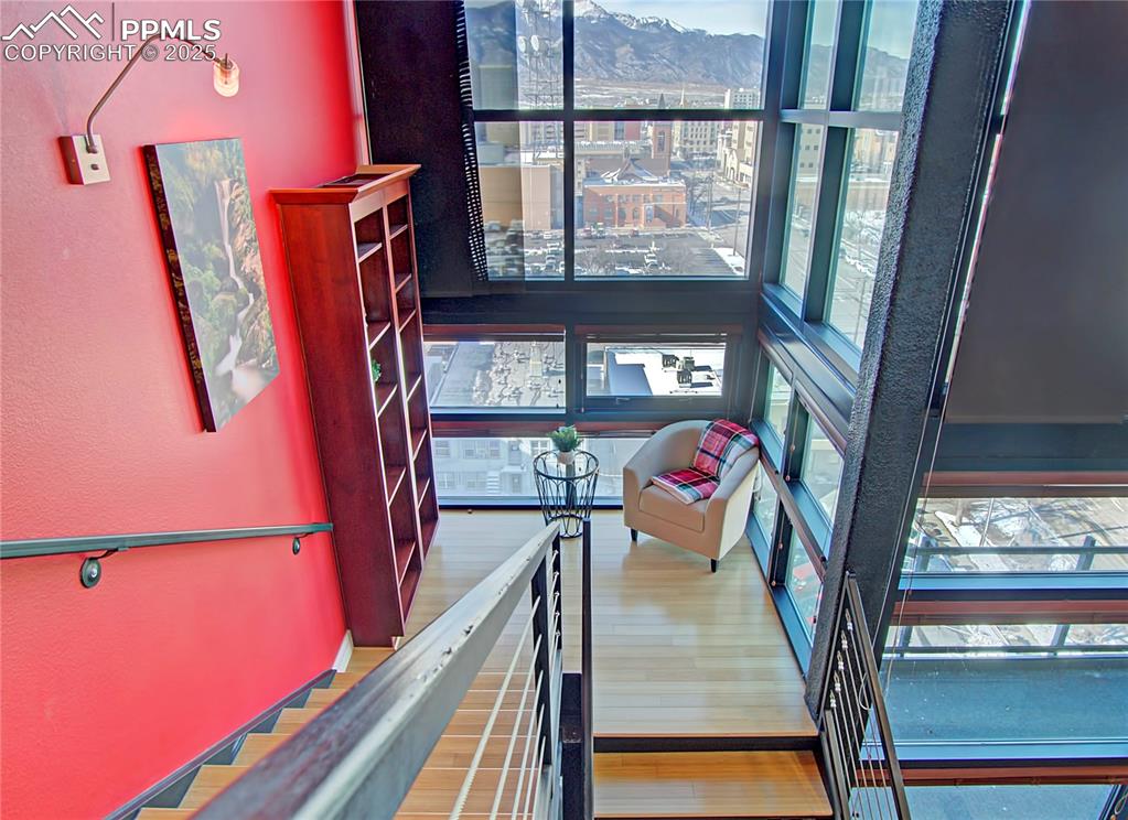 Staircase featuring healthy amount of natural light, wood finished floors, and a textured wall