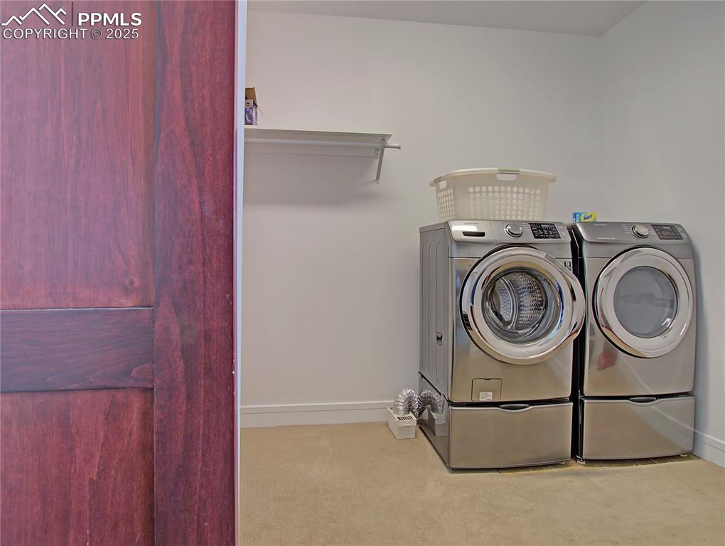 Washroom with carpet flooring and washer and dryer
