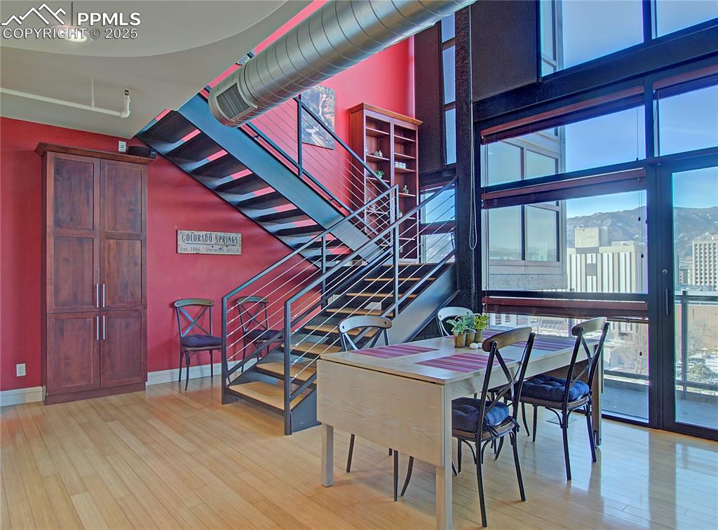 Dining room featuring light wood-type flooring, stairs, and expansive windows
