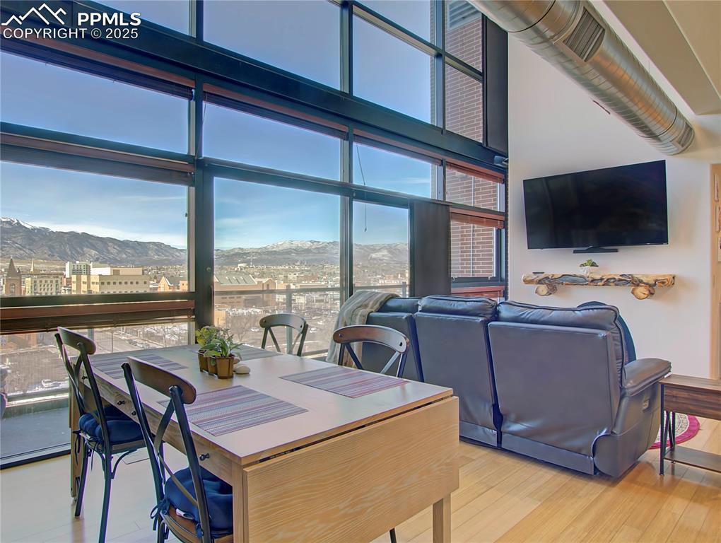Dining area featuring a mountain view, wood finished floors, and expansive windows