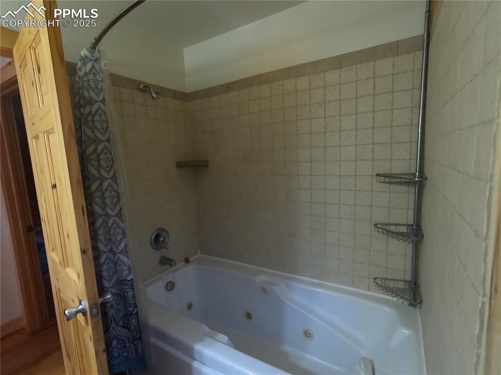 Bathroom with a combined bath / shower with jetted tub