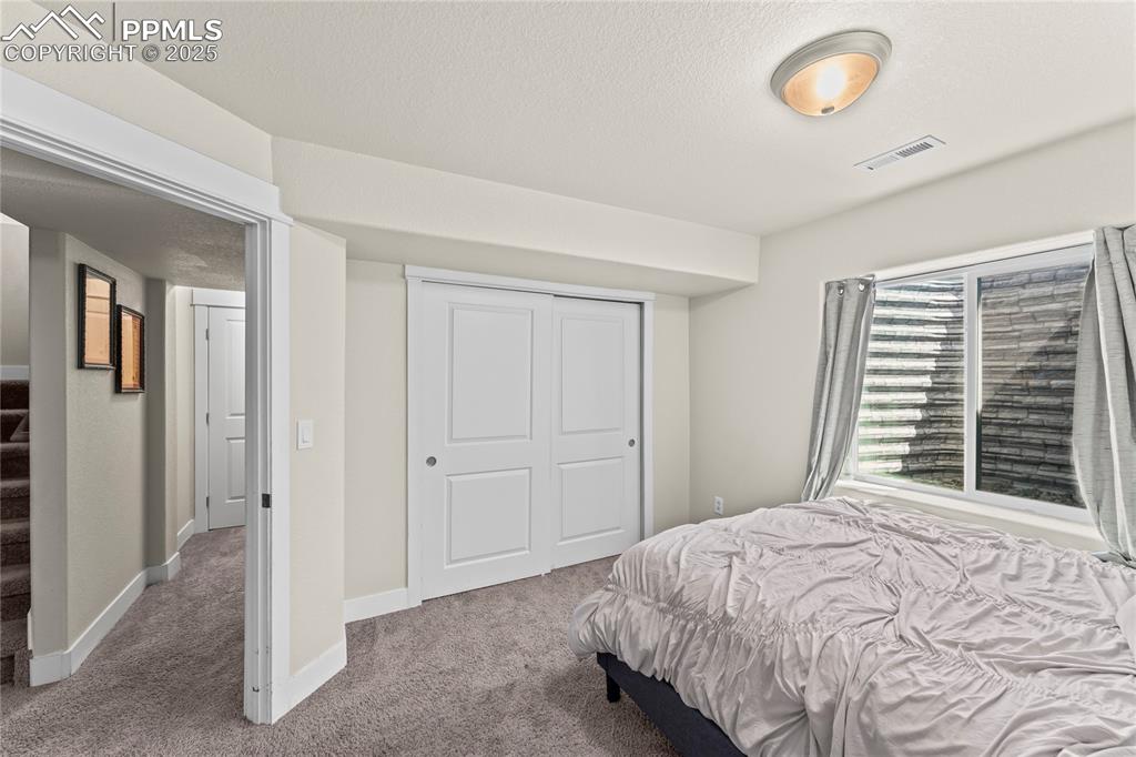 Bedroom featuring carpet floors, a closet, and a textured ceiling