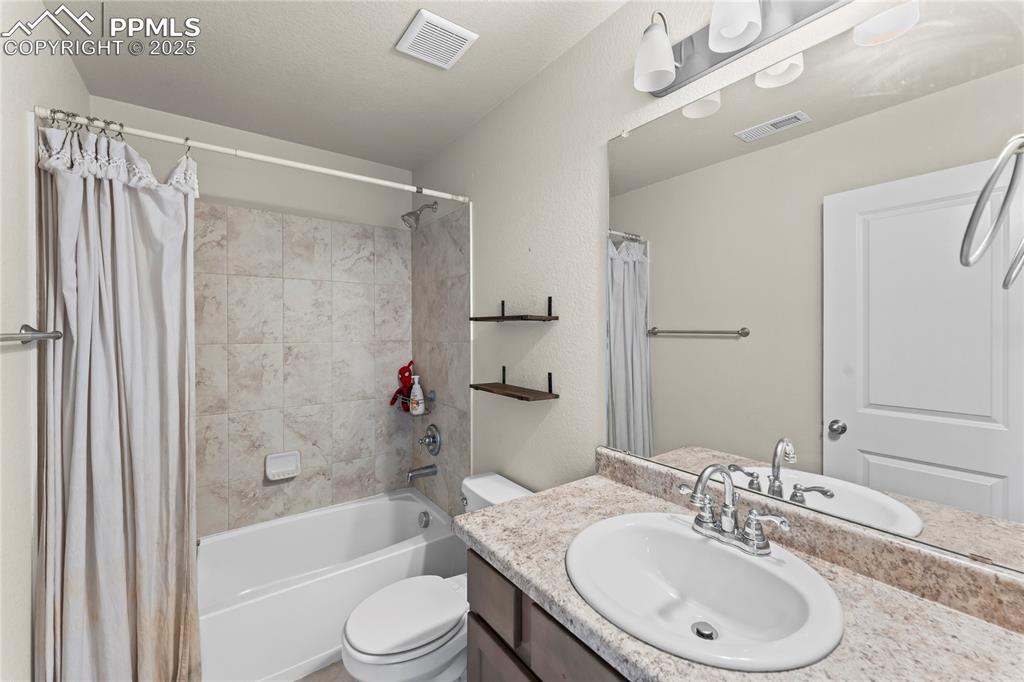 Bathroom featuring shower / bath combination with curtain and vanity