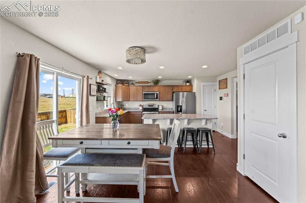 Dining area with dark wood finished floors and recessed lighting