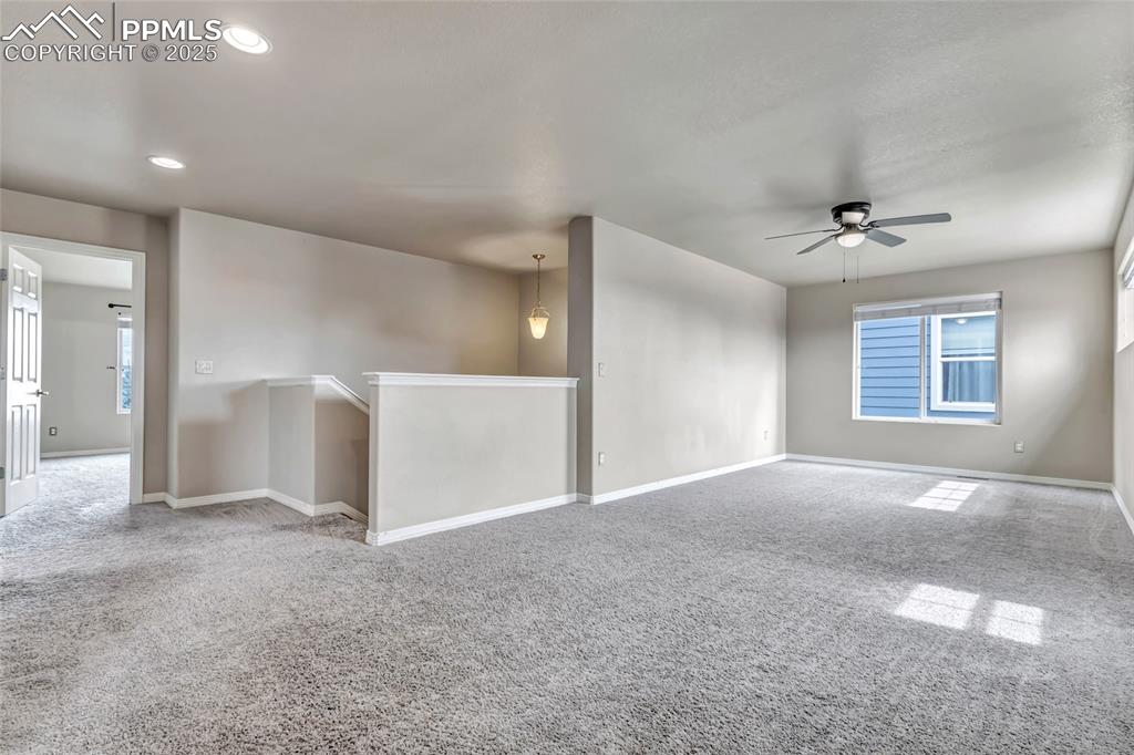 Carpeted spare room featuring ceiling fan and recessed lighting