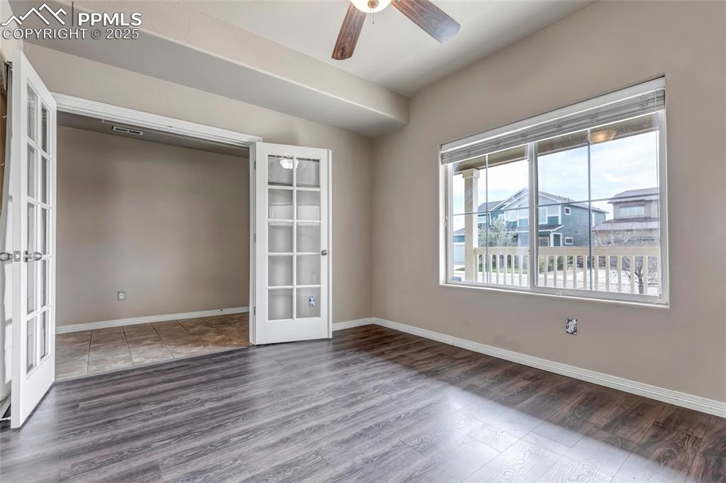 Unfurnished room with french doors, wood finished floors, and a ceiling fan