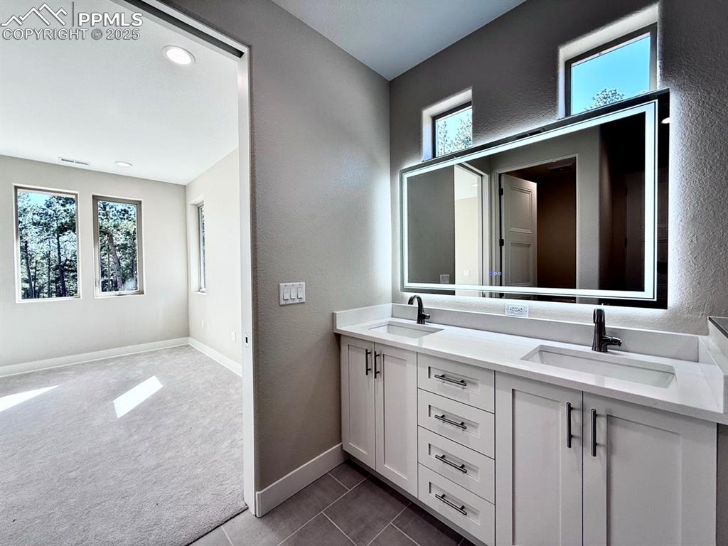Luxurious Primary Bathroom with Double Vanities, Quartz Countertops, Heated Mirror to avoid Fogging, Deep Soaking Tub, Large Shower with Bench and Glass Door.